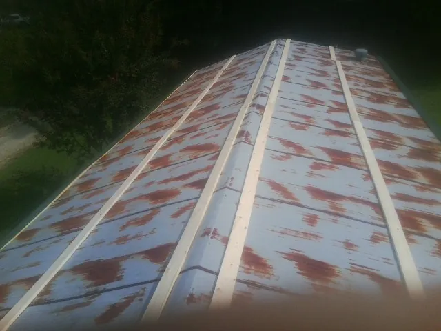 Rusted metal roof panels with new wood purlins before replacement — Storm Damage Roof Repair in Hoffman Estates by Roofing Brothers