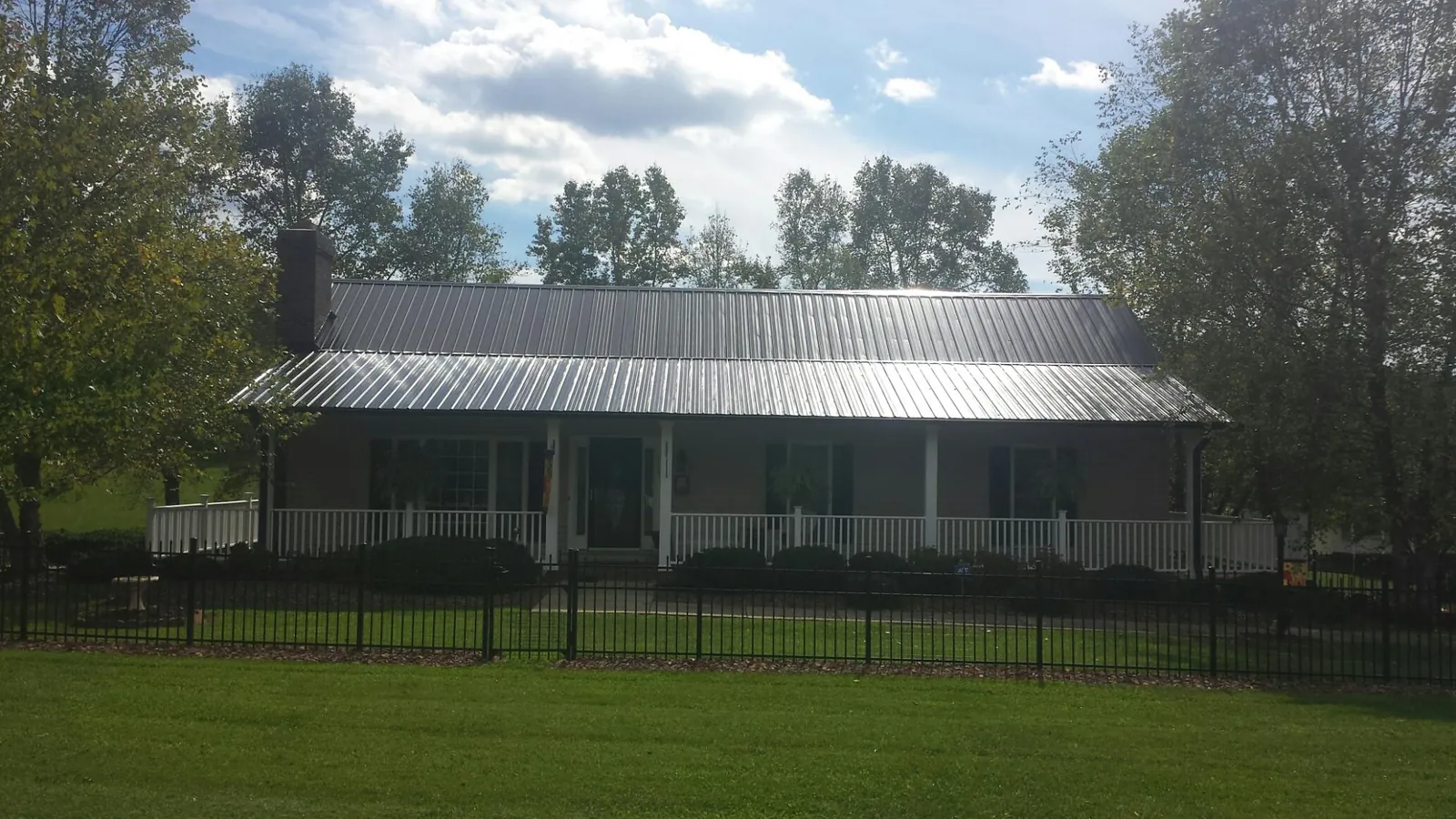 Gray metal roof on a brick ranch with a full width front porch — Gutter Guard Installation work by our crew in Hoffman Estates