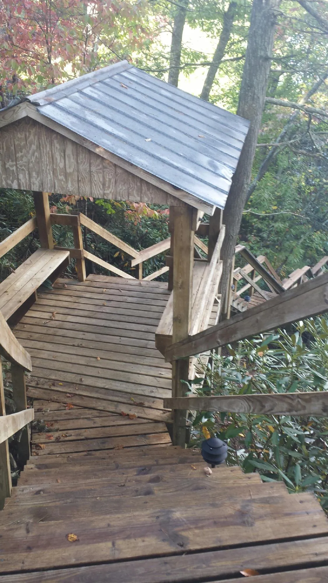 Metal roofed shelter over wooden steps on a wooded walkway — Skylight Repair & Installation work by our crew in Hoffman Estates