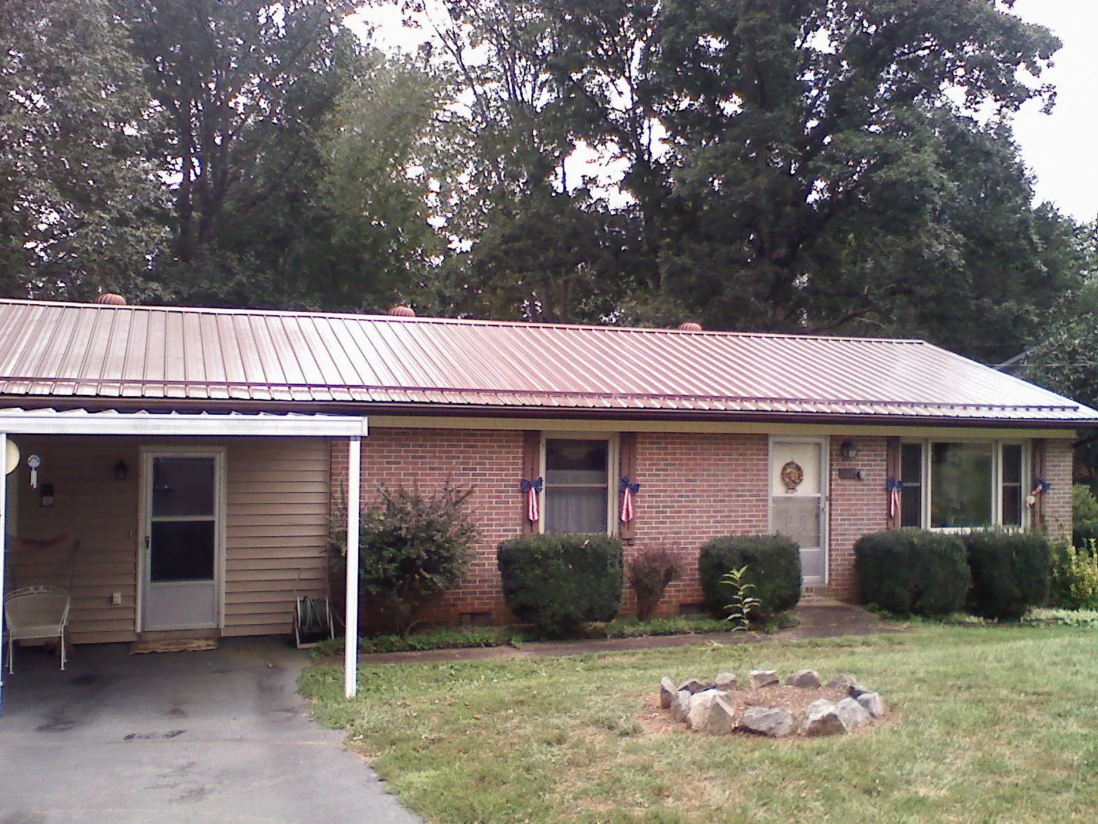 Bronze metal roof and carport on a brick ranch home — Roof Repair work by our crew in Hoffman Estates